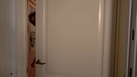 Guy opens the white door. Girl stands behind him. They are happy. People welcome Stock-Footage 99742853