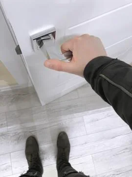 The guy opens the white door. Silver door handle close up. Stock Photos