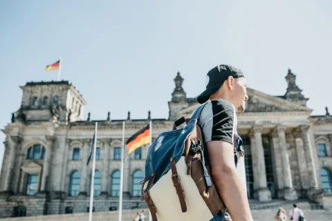 A guy or a tourist with a backpack next to the Reichstag building in Berlin. Stock Photos