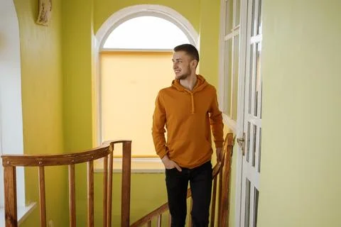 A guy in orange clothes is walking up the stairs Stock Photos