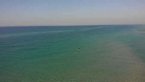 A guy with a paddle standing on a surfboard, top view Stock Footage 147475673