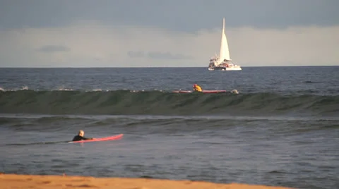 Guy Paddling an Outrigger surfer in foreground Video stock 25240459