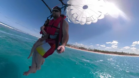 Guy parasailing over carribean behind a boat Stock Footage 87056938