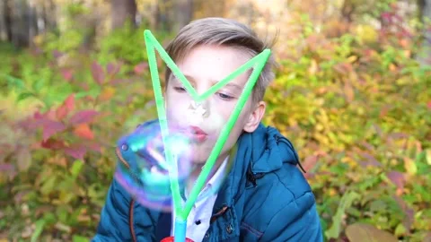 The guy in the Park is making bubbles. Leisure and entertainment in the fresh Vídeo Stock 96325146