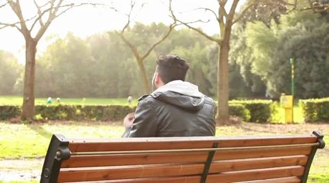 Guy at park with mp3 player Stock Footage 10580057