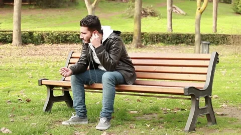 Guy at park with mp3 player Stock Footage 10582701