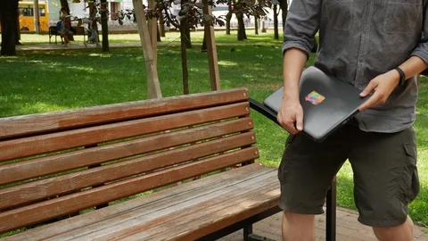 Guy in the park working on a laptop on a sunny day Stock Footage 113293368
