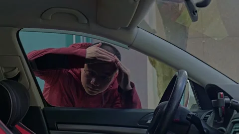 A guy peers inside through the car window, blocked by tint. Stock Footage 329165417