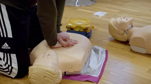 A guy performing cpr on a training doll Stock Footage 233898185