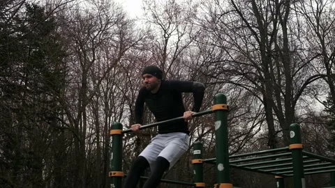 Guy performs an exercise going out on two hands on a crossbar Stock Footage 237986549