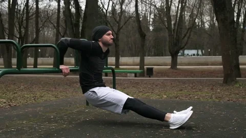 The guy performs the exercise reverse push-ups on the triceps from the crossbar Stock Footage 237988397
