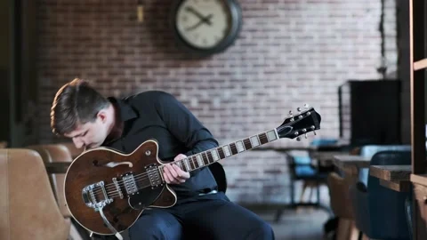 Guy performs jazz, blues music on guitar in bar. Retro studio, brick interior Stock Footage 135356350