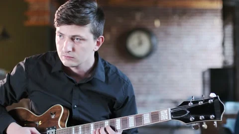 Guy performs jazz, blues music on guitar in bar. Retro studio, brick interior Stock Footage 135356682