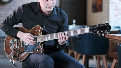 Guy performs jazz, blues music on guitar in bar. Retro studio, brick interior Stock Footage 135356718