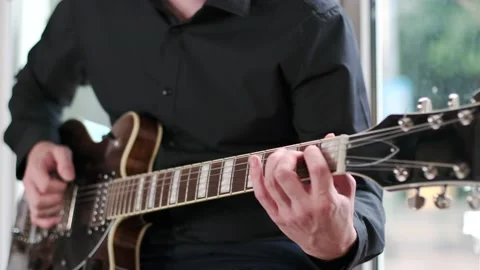 Guy performs jazz, blues music on guitar, sitting on windowsill in bar Stock Footage 135357022