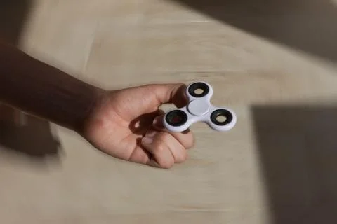A guy performs a trick with the finger spinner Stock Photos