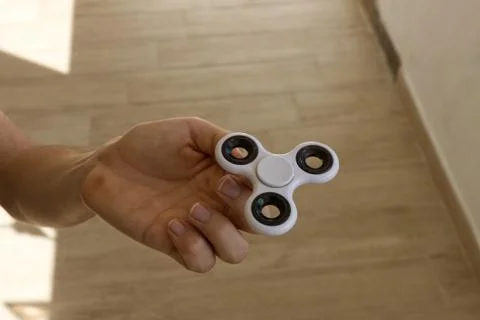 A guy performs a trick with the finger spinner Stock Photos