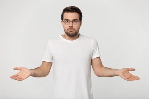 Guy in perplexity shrugged his shoulders studio shot Stock Photos
