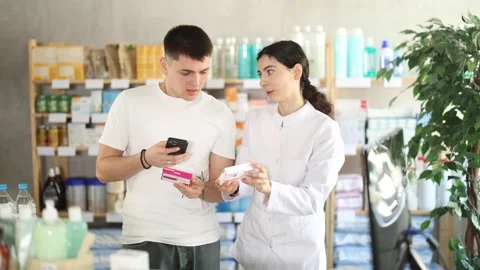 Guy in pharmacy scans QR code on tablet paracetamol, pharmacist i background Stock Footage 329395186