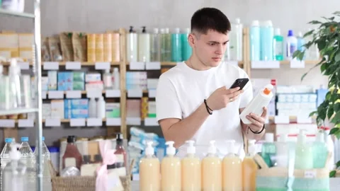 Guy in pharmacy scans QR code on emollient cream Stock Footage 341426791