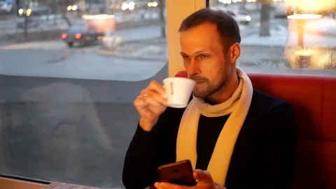 The guy with the phone is drinking coffee and talking 動画素材 102545844