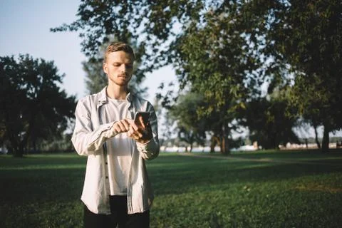 A guy with a phone in park Stock Photos