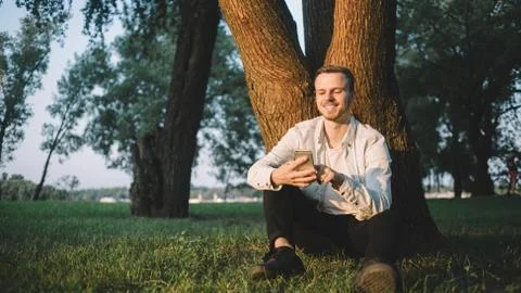 A guy with a phone in park Stock Photos