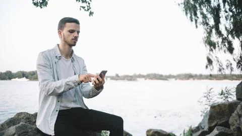 A guy with a phone in park Stock Photos