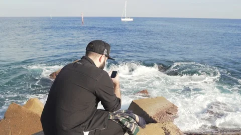The guy is photographing strong waves at the pier beach Stock Footage 101269613