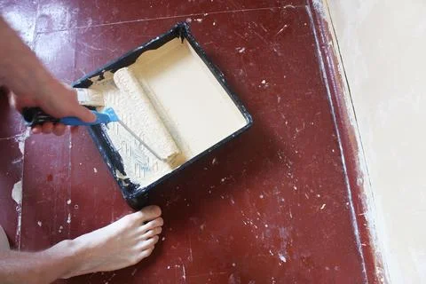 Guy picking up paint on a roller close-up Stock Photos
