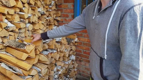 Guy picks up firewood in his hands and goes into the bathhouse Video stock 80408802