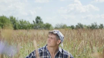The guy with the Plaid Shirt is Looking for something in the Field Stock Footage 85486683