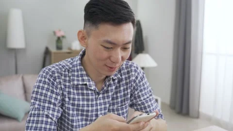 Guy in plaid shirt is smiling while sending text Stock Footage 160345906