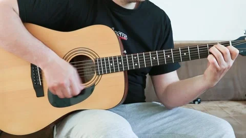 Guy playing an acoustic six-string guitar. Stock Footage 131022340