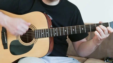 Guy playing an acoustic six-string guitar. Stock Footage 131022343