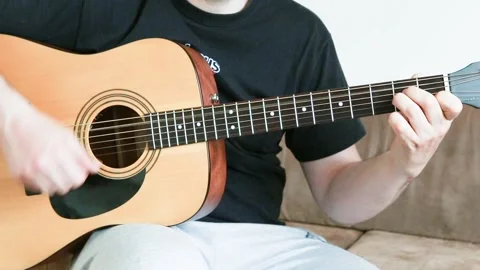 Guy playing an acoustic six-string guitar. Stock Footage 131022352