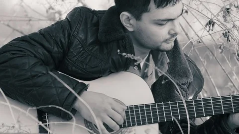 The guy playing the guitar in nature (b&amp;w) Stock Footage 74002332