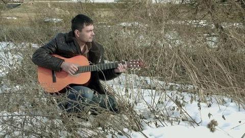 The guy playing the guitar in nature Stock Footage 73993945