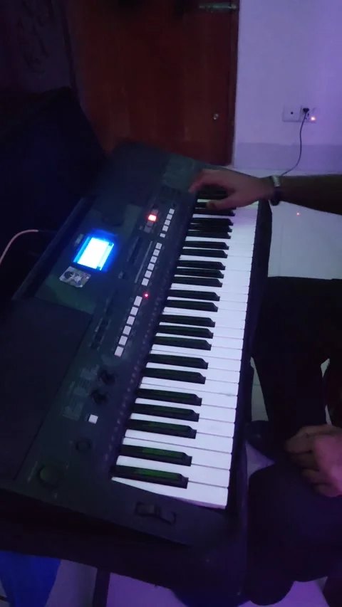 A guy playing his black keyboard with ambient lighting Stock Footage 171419350