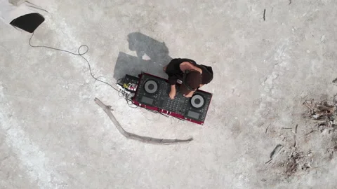 The guy playing music behind the DJ set in the chemical desert. Stock Footage 172287141