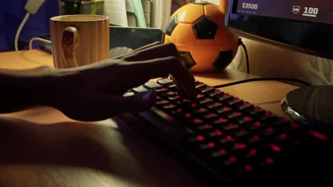 A guy plays on the computer at night and presses on the keyboard Stockbeeldmateriaal 253183952