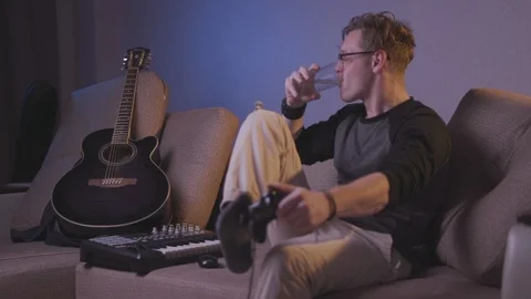 The guy plays the game console with his feet Stock Footage 118857843