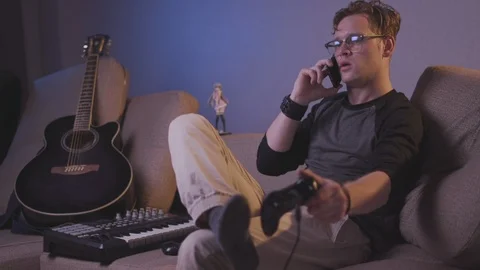 The guy plays the game console with his feet Stock Footage 118857851