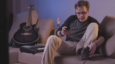 The guy plays the game console with his feet Stock Footage 118857852