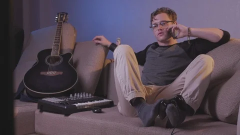 The guy plays the game console with his feet Stock Footage 118857862