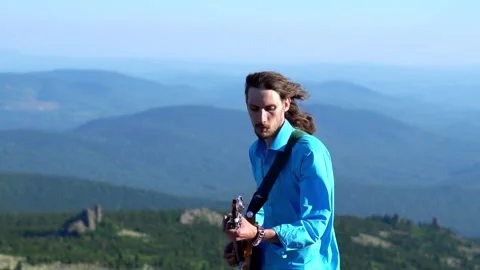 Guy plays guitar on the field Stock Footage 135792973