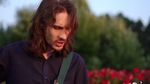 Guy plays guitar on the field Stock Footage 135952304