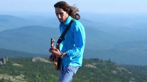Guy plays guitar on the field Stock Footage 136991239
