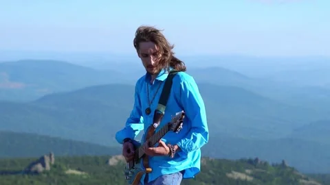 Guy plays guitar on the field 스톡 동영상 137222095