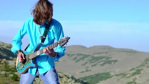 Guy plays guitar on the field Stock Footage 137454144